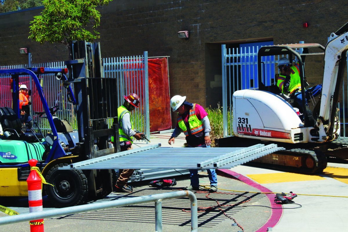 Construction on the fence takes place in front of the West 200 Building.